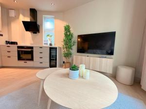 a living room with a table and a tv at Bergen City Apartment in Bergen