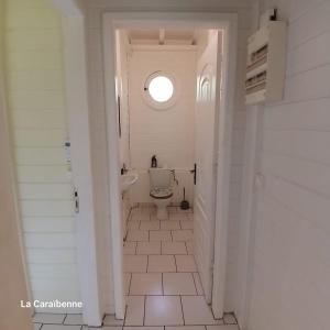 ラ・トリニテにあるLa Maison Verteのトイレと窓のある白いバスルーム