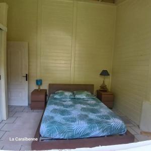 ラ・トリニテにあるLa Maison Verteの2つのナイトスタンドと青いベッドのある部屋のベッド