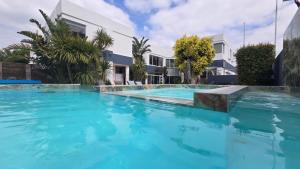 a large swimming pool with blue water in front of a building at Hermanus Manor in Hermanus