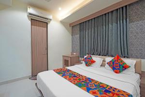 a hotel room with two beds and a window at FabHotel New Empire in Ahmedabad