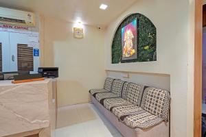a waiting room with a couch and a window at FabHotel New Empire in Ahmedabad