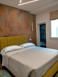 a bedroom with a large bed with a yellow headboard at Modus Boutique Hotel in Faenza