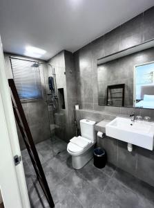 a bathroom with a toilet and a sink at Timurbay Residences in Kuantan