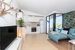 カラ・サンタンドリアにあるSa Perdiu 14 Menorcaの青いソファとキッチンのあるリビングルーム