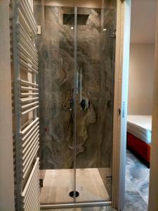 eine Dusche in einem Raum mit einer Steinwand in der Unterkunft Modus Boutique Hotel in Faenza + 36 Fotos