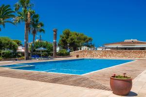 una piscina en un complejo con palmeras en Sa Perdiu 14 Menorca, en Cala Santandria