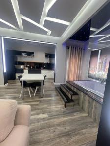 a living room with a table and a kitchen at Luxury Suite Korca in Korçë