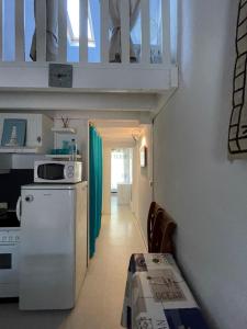 a kitchen with a white refrigerator and a table at Maisonnette - M04231 in Soulac-sur-Mer