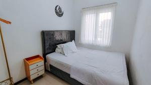 Postel nebo postele na pokoji v ubytování Villa Keluarga Royal Arois Unit A-01