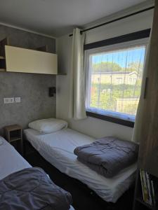 Postel nebo postele na pokoji v ubytování Mobilhome Camping Le Lac des Rêves