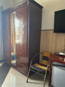 a room with a chair and a wooden cabinet at Khách sạn Ngọc Thủy in Phan Rang