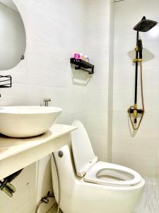 a bathroom with a white toilet and a sink at Ariel Homestay in Quy Nhon