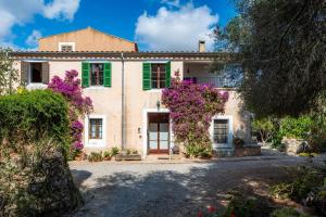 a house with purple flowers in front of it at Finca Es Galliner in Es Carritxo