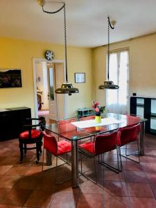 a dining room with a table and red chairs at Cuore della Città- Manerbio in Manerbio +9 photos