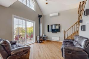 a living room with a couch and a tv at Spa Lake - Naturo lac Sept-Iles in Saint-Raymond