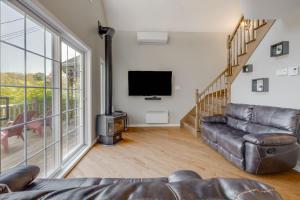 a living room with a couch and a flat screen tv at Spa Lake - Naturo lac Sept-Iles in Saint-Raymond