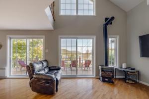 a living room with a leather couch and a television at Spa Lake - Naturo lac Sept-Iles in Saint-Raymond
