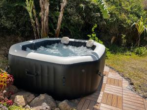 a hot tub sitting on a wooden deck at La Ravine, Luxe, avec Jacuzzi, Vue unique et Lit à eau in Saint-Joseph