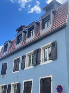 a white building with windows and a red roof at Thann centre, 2 BR, terrasse exposée sud, vue sur la Collégiale in Thann