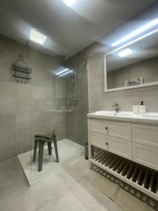 a bathroom with a sink and a mirror and a stool at Thann centre, 2 BR, terrasse exposée sud, vue sur la Collégiale in Thann