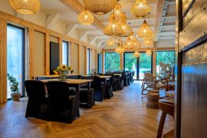 a dining room with tables and chairs and chandeliers at Sowia Ostoja Góry Sowie in Ludwikowice Kłodzkie
