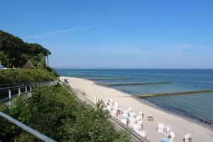una playa con un montón de sillas y el océano en Bungalow Bernstein, en Ostseebad Nienhagen