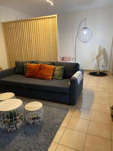 a living room with a couch and two tables at Au Cœur De L'alsace in Ostheim