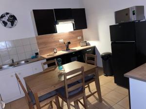 a small kitchen with a wooden table and chairs at Au Cœur De L'alsace in Ostheim +10 photos