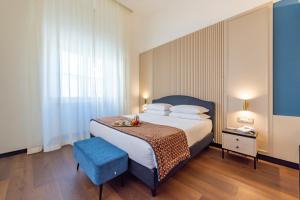 Un dormitorio con una cama grande y una silla azul. en Best Western Hotel Artdeco, en Roma 94 fotos más