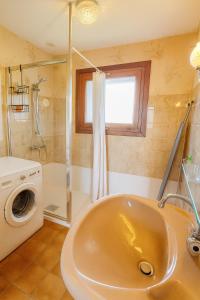 a bathroom with a sink and a washing machine at Maison Au Calme des Pyrénées in Nestier