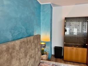 een woonkamer met een bank en een blauwe muur bij SHoliday 1 Bedroom Balcony &Free Parking in Timişoara