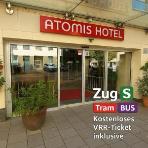 a hotel with a sign on the front of a building at Atomis Hotel Düsseldorf City in Düsseldorf