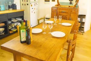 a wooden table with wine bottles and glasses on it at Maison Au Calme des Pyrénées in Nestier