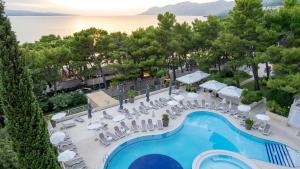 an overhead view of a swimming pool with chairs and tables at Hotel Horizont in Baška Voda