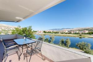 a balcony with a table and chairs overlooking a river at House Pag Vacation House in Pag