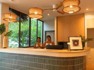 two women standing in front of a bathroom mirror at Where Is Hostel - Koh Tao in Koh Tao