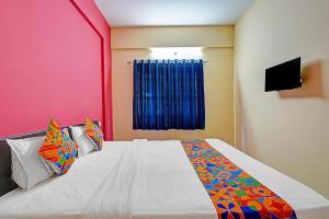 Un dormitorio con una cama blanca con una manta colorida. en Via SLV Suites, en Bangalore