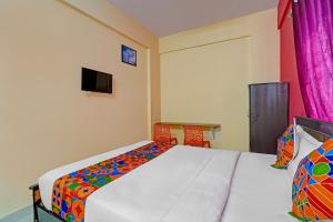 1 dormitorio con 1 cama, TV y cortinas en Via SLV Suites, en Bangalore