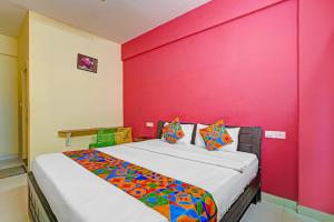 Un dormitorio con una pared rosa y una cama en Via SLV Suites, en Bangalore