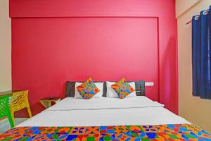 Un dormitorio con una cama con una pared roja. en Via SLV Suites, en Bangalore