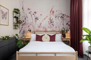 1 dormitorio con 1 cama con pared de flores en Hotel Botanica by goodnite cz, en Brno