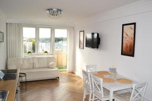a living room with a white couch and a table at Cosy Studio Gdynia Kamienna Góra in Gdynia