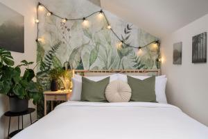 a bedroom with a large bed with lights above it at Hotel Botanica by Goodnite cz in Brno