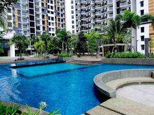 a large blue swimming pool with buildings in the background at Timurbay Residences in Kuantan +20 photos