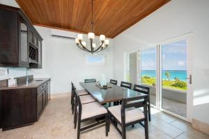 a dining room with a table and chairs and the ocean at Sky Beach Club Split - Contemporary Beach Villa In Boutique Club villa in Colebrooke Dale +30 photos
