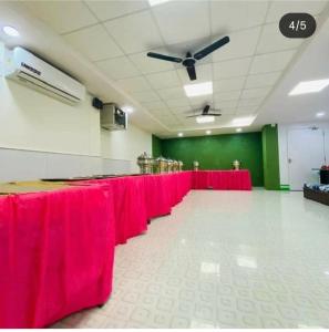 a long row of red tables in a room at Hotel Royal Excellency inn in Satna +12 photos