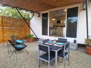 a patio with a table and chairs and a house at BlueStone Residence in Brasilito