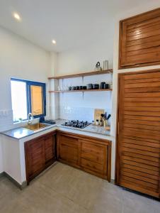 a kitchen with a sink and a stove top oven at Villa le Baobab in Bikondo +6 photos