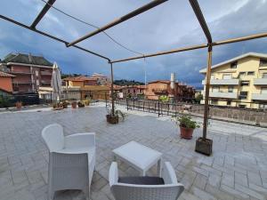 a patio with white chairs and a white table at la gatta bianca in Marino